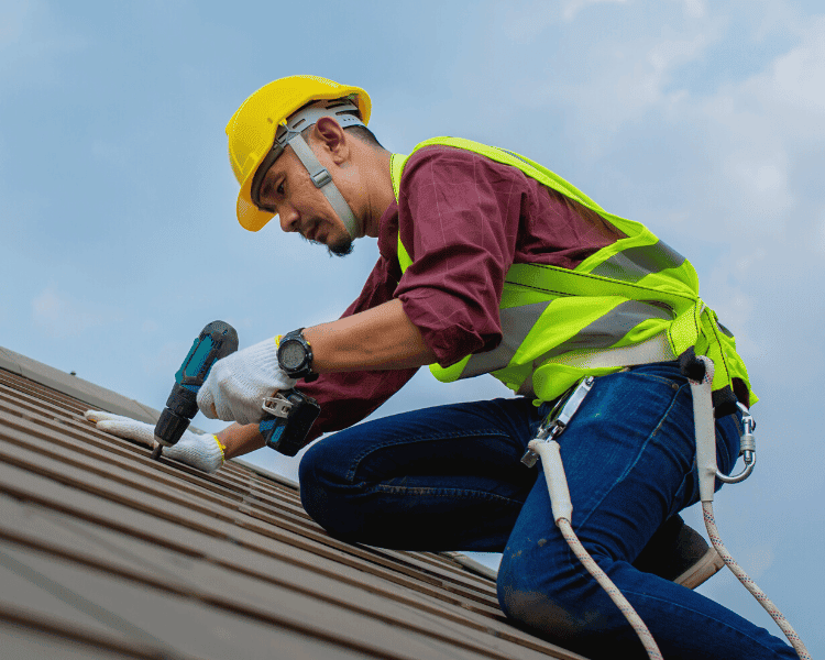 A skilled worker drilling on the roof